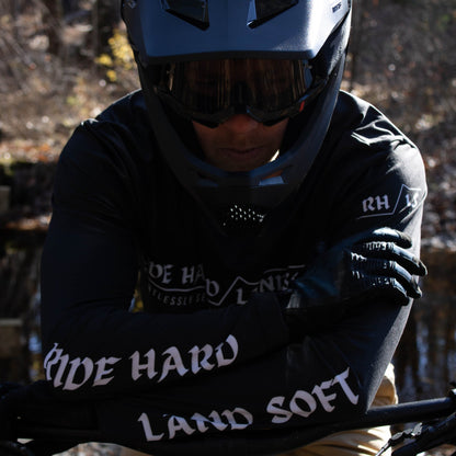 Mountain biker with arms crossed resting on handlebars